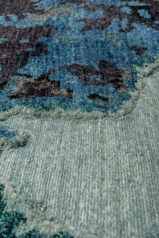 Geba Teppich "Antique blue" in abstrahierter Darstellung eines klassischen Teppichs, verschiedene blau und grau Töne, mit Bordüre, aus Nepal, 100 Knoten, gefertigt aus 90% tibetischer Hochlandschafwolle und 10% chinesischer Seide - Produktbild - Geba Teppich