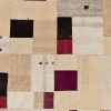 Patchwork Teppich mit verschiedenen Farben, Grundfarbe ist beige in unterschiedlichen Tönen, rot-schwarze Patches verteilt über den Teppich, vereinzelte bunte Schneeflocken gestickt, aus Anatolien, gefertigt aus Schafwolle - Produktbild - Geba Teppich
