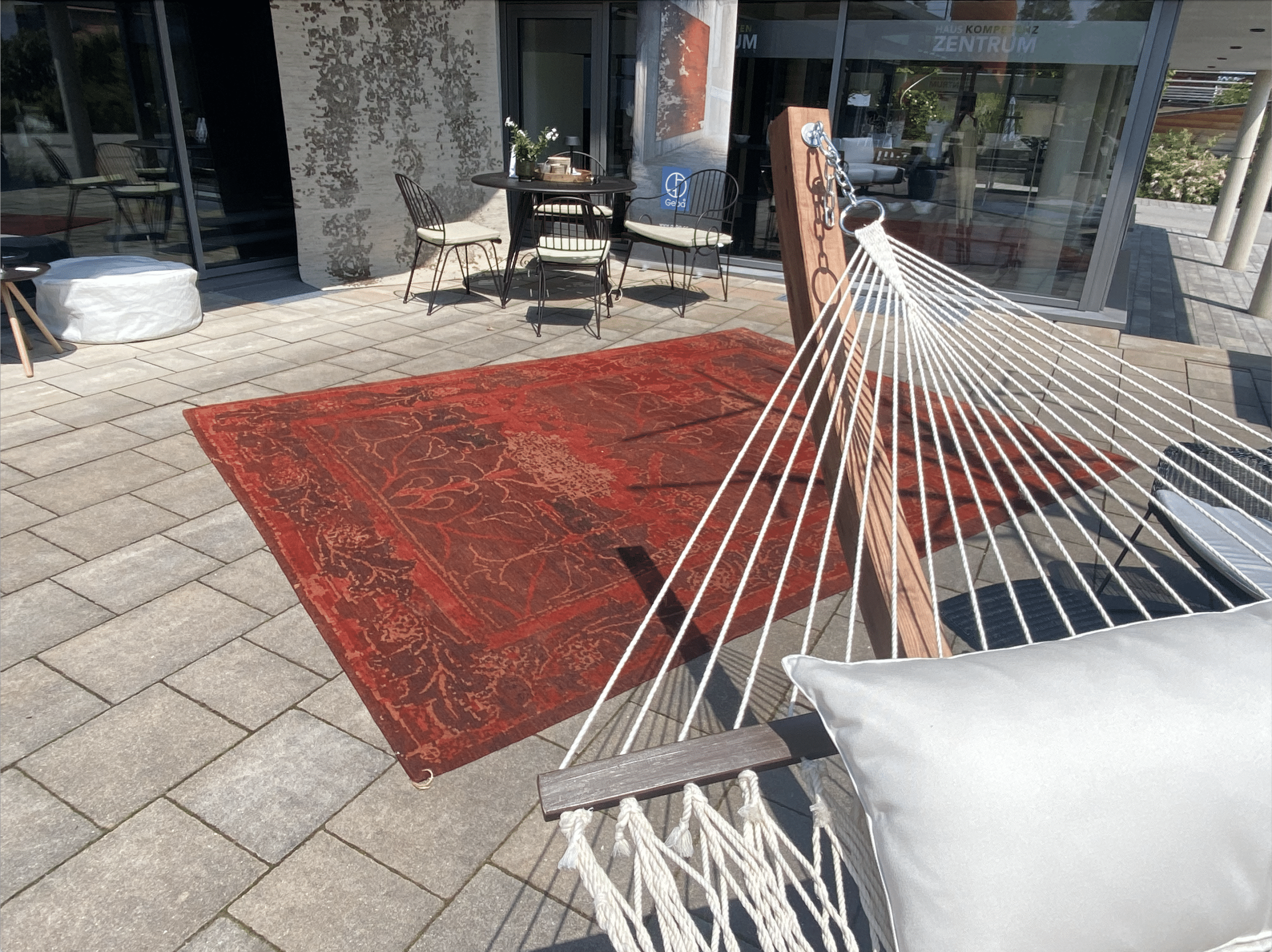 Geba Teppich Donegal red auf dem Boden liegend neben einer Hängematte